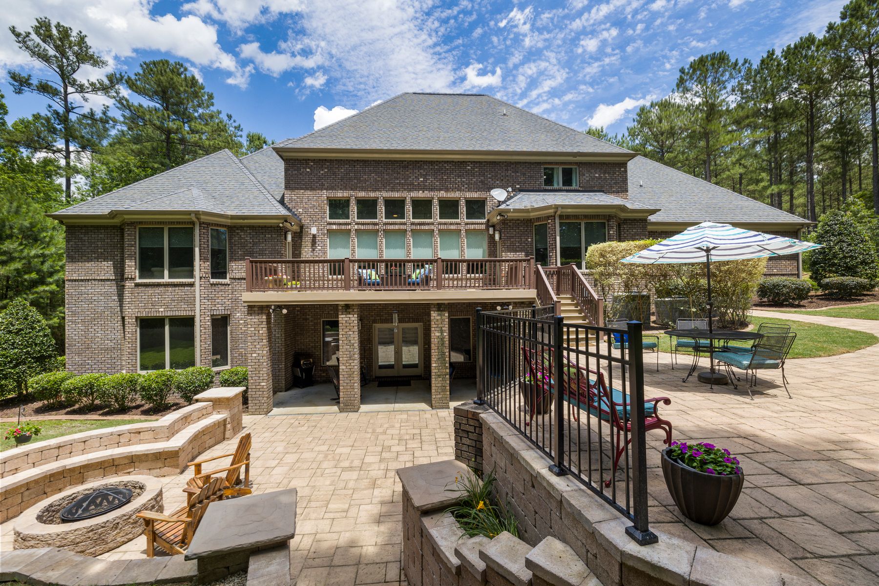 Brick home with a stone terrace, fire pit and landscaped garden beds